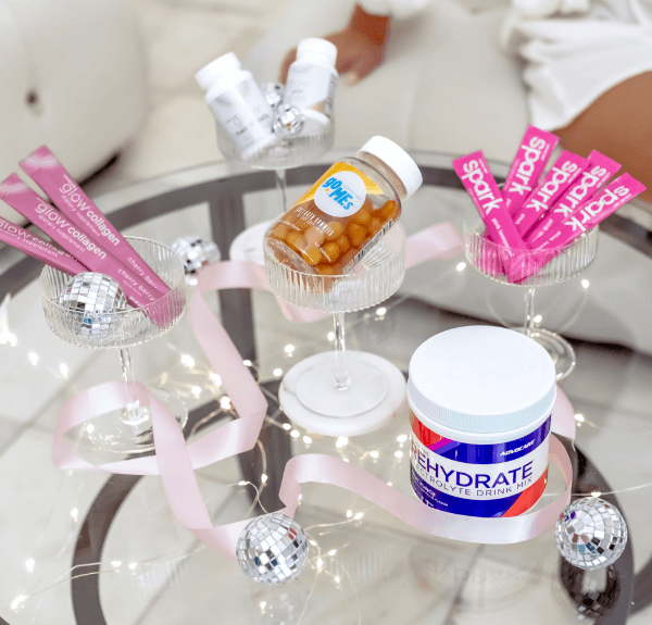 AdvoCare products on a glass table with festive decorations and white lights