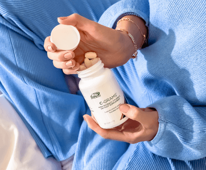 A woman holding an open bottle of C-Grams