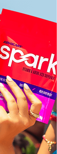 Hand holding a bag of Spark Fruit Punch stick packs.