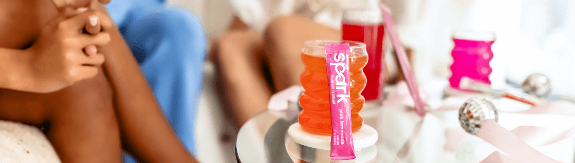 Prepared Spark, Glow, and Rehydrate on a glass table with three women sitting on a sofa next to it.