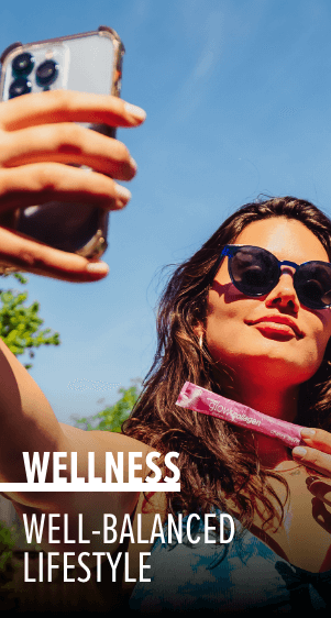 A woman holding a stick pack of Glow Collagen taking a selfie. Wellness. Well-balanced lifestyle