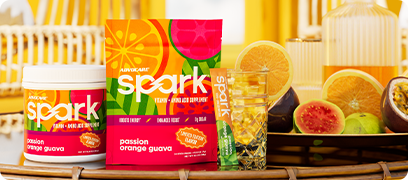 Spark Passion Orange Guava canister and stick pack bag in a summery beach house setting.