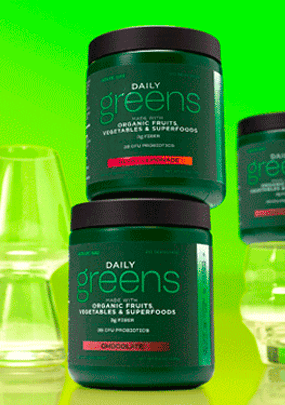 AdvoCare Daily Greens canisters stacked next to empty drinking glasses on a green backgorund
